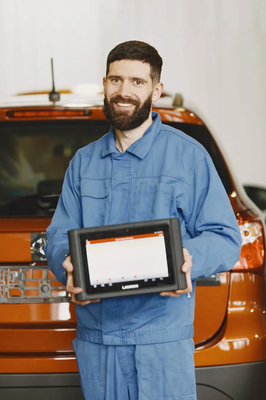 Mecanic care folosește un dispozitiv portabil de diagnoză auto